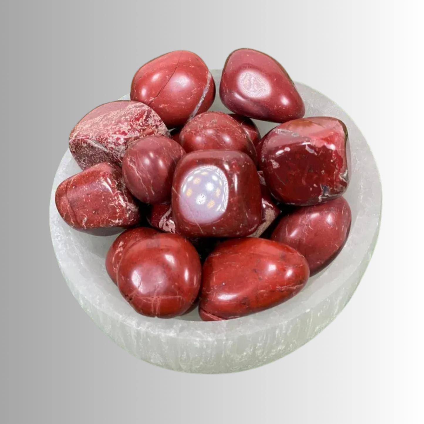 Tumbled Red Jasper crystal in deep red to crimson hues with natural flecks, used for grounding, strength, protection, and endurance